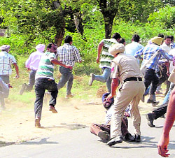 A policemen overpowers a protesting veterinary pharmacist in Lambi as others flee