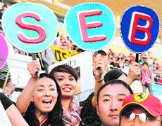 Japanese fans of Red Bull-Renault driver Sebastian Vettel wave boards with his name ahead of Japanese GP at Suzuka on Thursday. 