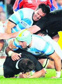 NZ’s Richie McCaw (above) is tackled by Argentina's Juan Manuel (c)