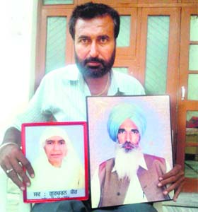 Lakhveer Singh with pictures of his parents who died of cancer