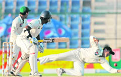 Kumar Sanngakkara (C) and Pakistan wicketkeeper Adnan Akmal (L) look on as Younis Khan (R) drops a catch on the fourth day of the first Test