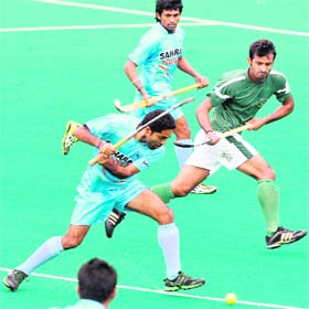 India�s Ravi Pal (L) hits the ball against Pakistan during their match at the International Super Series in Perth on Sunday