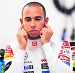 McLaren driver Lewis Hamilton plugs his ears in the pits during a practice session at the Buddh International Circuit in Greater Noida on Friday
