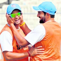 Robin Uthappa (R) laughs with Suresh Raina during a practice session in Kolkata on Friday