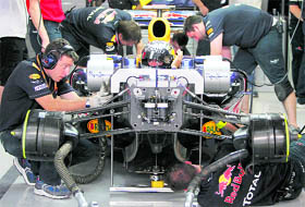 A file photo of Red Bull Formula One driver Sebastian Vettel sitting in his car as mechanics work on the car in the garage.