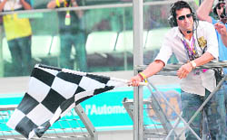 Sachin Tendulkar waves the chequered flag for Red Bull Formula One driver Sebastian Vettel as he crosses the finish line to win the Indian Grand Prix in Greater Noida on Sunday.