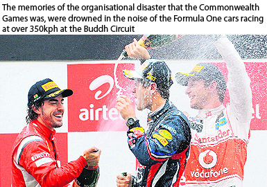 Red Bull-Renault driver Sebastian Vettel (C) is doused with champagne by McLaren-Mercedes driver Jenson Button and Ferrari driver Fernando Alonso of Spain after winning the Formula One Indian Grand Prix on Sunday.