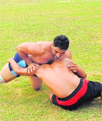 An Indian raider (L) vies with a stopper from Nepal during their Kabaddi World Cup match in Moga on Friday