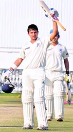 Suresh Raina of Uttar Pradesh raises his bat after completing his double century at PCA stadium, Mohali, on Saturday