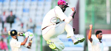 West Indies players celebrate the fall of an Indian wicket at the Ferozshah Kotla Stadium in New Delhi on Monday. 