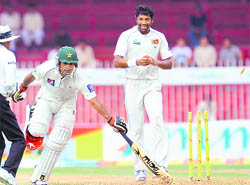 Pakistan's Mohammad Hafeez (C) is run out as Sri Lankan pacer Chanaka Welegedara (R) looks on during the final day of the third Test in Sharjah on Monday. 
