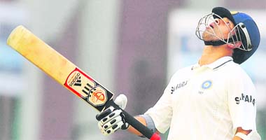 Sachin Tendulkar raises his bat and looks to the sky after completing 15,000 Test runs during the third day of the first Test against West Indies at the Ferozeshah Kotla stadium in New Delhi on Tuesday