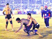 A player from Afghanistan catches a raider from Nepal during their Kabaddi World Cup match in Patiala on Tuesday