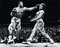File photo of Joe Frazier (R) punching Muhammad Ali