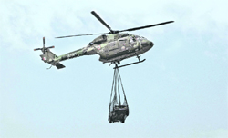 An undersling operation, where a vehicle is being carried, as a part of the ongoing silver jubilee celebrations of the Army Aviation Corps in the Western Command in Patiala on Wednesday. 