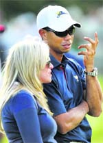 U.S. team member Tiger Woods talks to Phil Mickelson's wife Amy during the first round foursome matches at The Presidents Cup at Royal Melbourne Golf Club