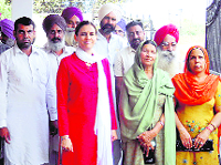 Manpreet Badal's wife Veenu Badal with her husband's supporters in Doda village on Wednesday. 
