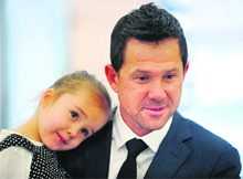 Ricky Ponting holds his daughter Emmy as he speaks to reporters in Sydney. 
