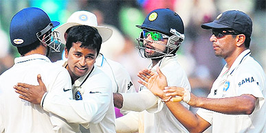 Pragyan Ojha (2L) celebrates with Mahendra Singh Dhoni (L), Virat Kohli (2R) and Rahul Dravid (R) during the third Test match against West Indies at The Wankhede Stadium in Mumbai on Saturday. 