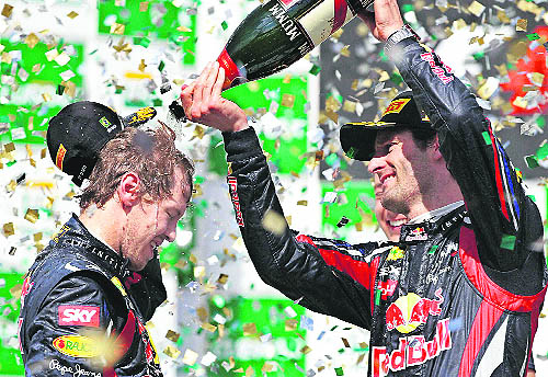 Red Bull driver Mark Webber (R) pours champagne on teammate Sebastian Vettel in Sao Paulo on Sunday.