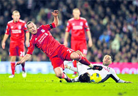 Liverpool's Charlie Adam (L) is tackled by Fulham's Clint Dempsey in London on Monday