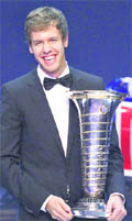 Red Bull Formula One driver Sebastian Vettel poses with his FIA trophy during the 2011 Federation Internationale de l'Automobile (FIA) gala night in Gurgaon