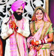 Former Indian hockey team captain Rajpal Singh (L) and shooter Avneet Kaur Sidhu pose for photographers after their marriage in Zirakpur on Sunday.