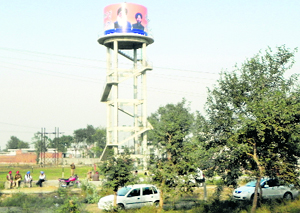 ; and (right) a giant poster of the CM and his son.