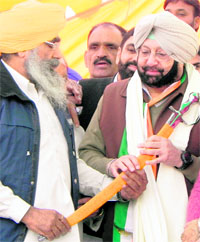 SGPC member Sukhjit Singh Kaka presents a sword to PCC chief Capt Amarinder Singh at a rally in Lohgarh in Moga on Wednesday