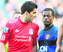 A file phot of Liverpool's Uruguayan forward Luis Suarez (L) exchanging words with Manchester United's French defender Patrice Evra during their match in Manchester. � AFP