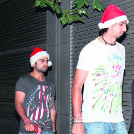 Cricketers Ishant Sharma (R) and Virat Kohli walk down a street on Christmas eve in Melbourne on Saturday. 