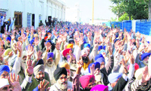 Supporters of Akali MLA Didar Singh Bhatti raise their hands in his support during a meeting at Gurdwara Jyoti Swarup in Fatehgarh Sahib on Monday.