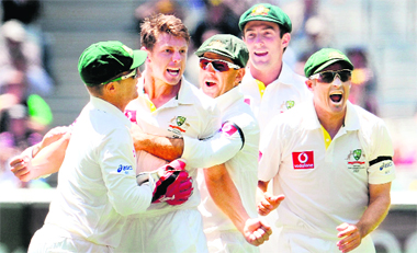 Australian paceman James Pattinson (2/L) celebrates with teammates after dismissing Rahul Dravid at the MCG on Thursday