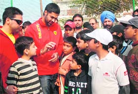 Punjab players Amit Uniyal (L) and Manpreet Gony giving tips to youngsters in Mohali on Sunday