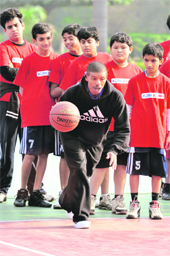 Former NBA player Muggsy Bogues (C) gives tips to school children in New Delhi on Monday. Bogues at 5�3� is the shortest player ever to have featured in