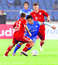 Baichung Bhutia (C) vies with Bayern Munich's Bastian Schweinsteiger (R) and Rafinha (L) during their friendly match in New Delhi on Tuesday. 
