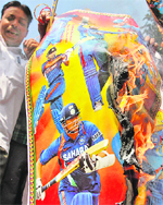 A cricket fan burns a poster with images of Indian cricketers, including captain MS Dhoni, during a protest against India's performance in the Test series against Australia in Ahmedabad on Monday. 