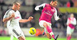 Swansea City's Steven Caulker (L) vies for the ball against Arsenal's Alex Oxlade-Chamberlain at The Liberty Stadium on Sunday.