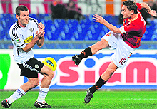AS Roma's forward Francesco Totti (R) kicks the ball in front of Cesena defender Maurizio Lauro during their Italian Serie A match in Rome on Saturday