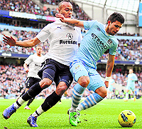 Manchester City's Sergio Aguero (R) holds off Tottenham Hotspur's Younes Kaboul during their match at the Etihad Stadium in Manchester on Sunday