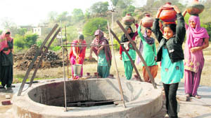Women draw water from a well. 