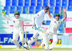 Pakistan's wicketkeeper Adnan Akmal (L) and Mohammad Hafeez (R) celebrate as England�s Stuart Broad is dismissed in Abu Dhabi on Saturday