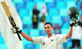Pakistan's Younus Khan raises his bat and helmet to celebrate his century during the second day of the third Test against England in Dubai on Saturday. 