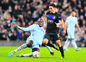 Manchester City's Yaya Toure (L) challenges Porto's Joao Moutinho during their Europa League match in Manchester on Wednesday. City won 4-0