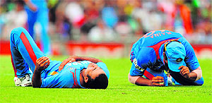 Suresh Raina (R) lies on the ground alongside teammate Irfan Pathan (L), after the pair collided as Raina took a catch to dismiss David Warner in Sydney on Sunday. India lost the match by 87 runs