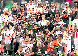 Indian players celebrate with the winners trophy after beating France in the final of the FIH London Olympics Hockey Qualifying tournament at the Dhyan Chand National Stadium in New Delhi on Sunday