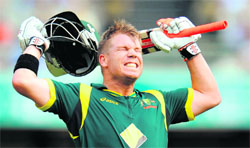 Australia�s David Warner celebrates his century against Sri Lanka in the first final at the Gabba in Brisbane on Sunday.