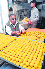 A sweet seller prepares for poll victory celebrations in Patiala. 