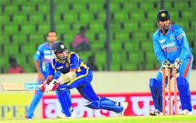 Sri Lankan captain Mahela Jayawardene (L) plays a shot as MS Dhoni (R) looks on during the Asia Cup ODI at the Sher-e-Bangla National Stadium in Dhaka on Tuesday