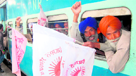 Kisan Sangharsh Committee members raise anti-government slogans at the Amritsar railway station on Sunday as they leave for Delhi.